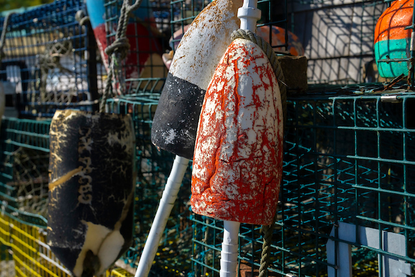 Lobster buoys next to a stack of lobster traps.