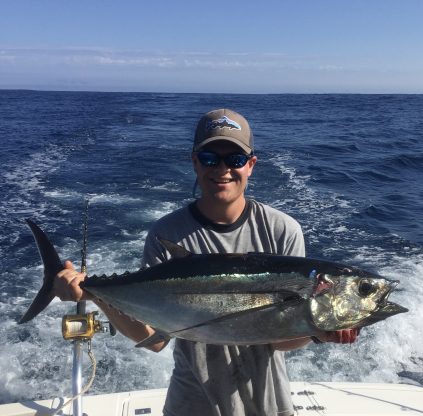 Blaise Jenner on boat holding large fish