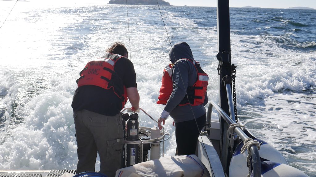 Students participating in sampling lab on a boat at the Darling Marine Center