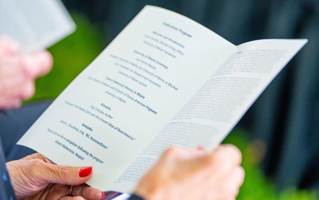 A photo of hands holding an event program