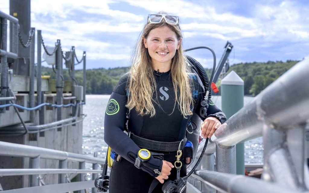 A photo of Sydney Ulland standing on a dock at the Darling Marine Center