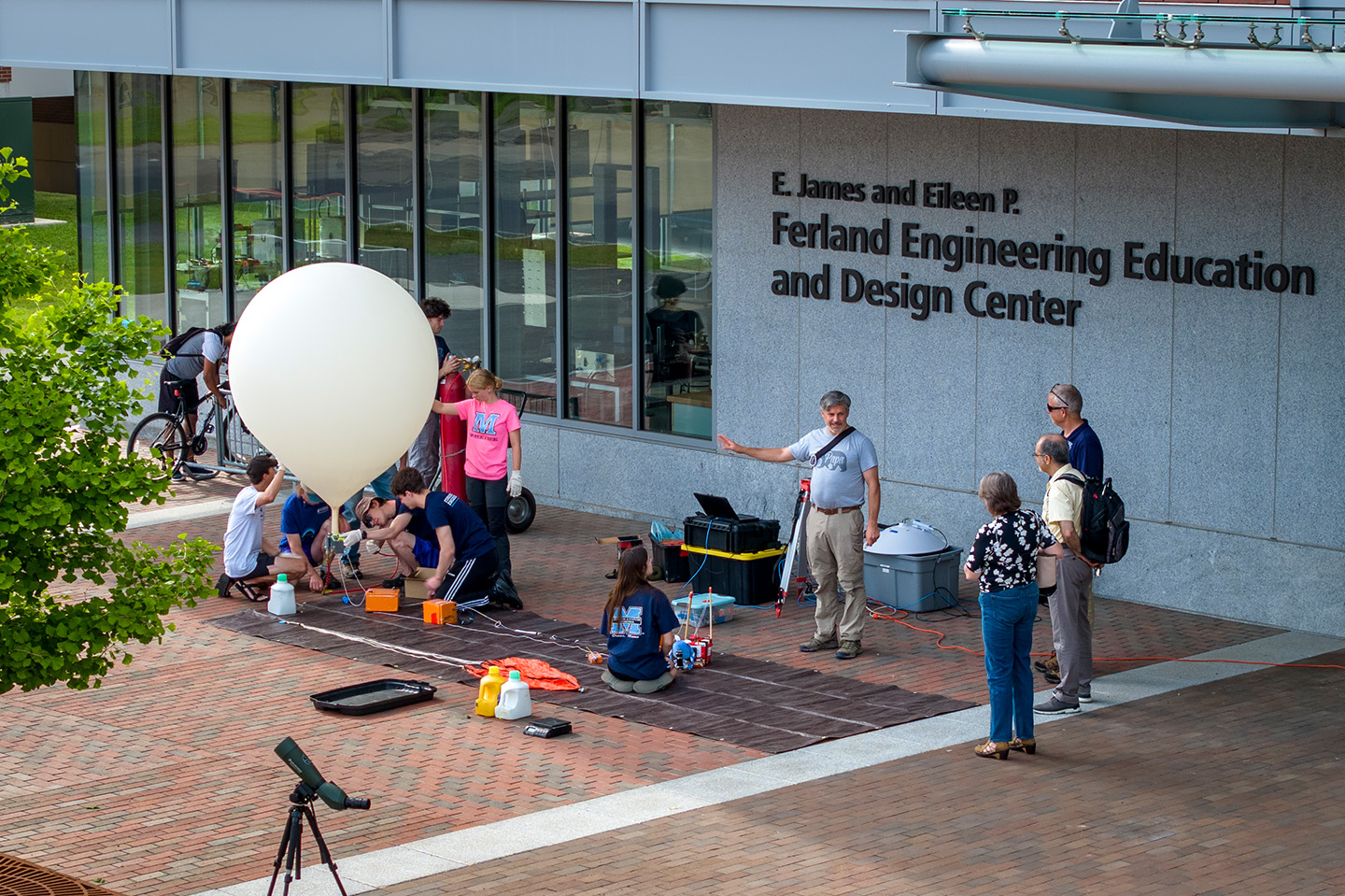 Students prepare to launch a weather balloon in front of the Ferland EEDC building