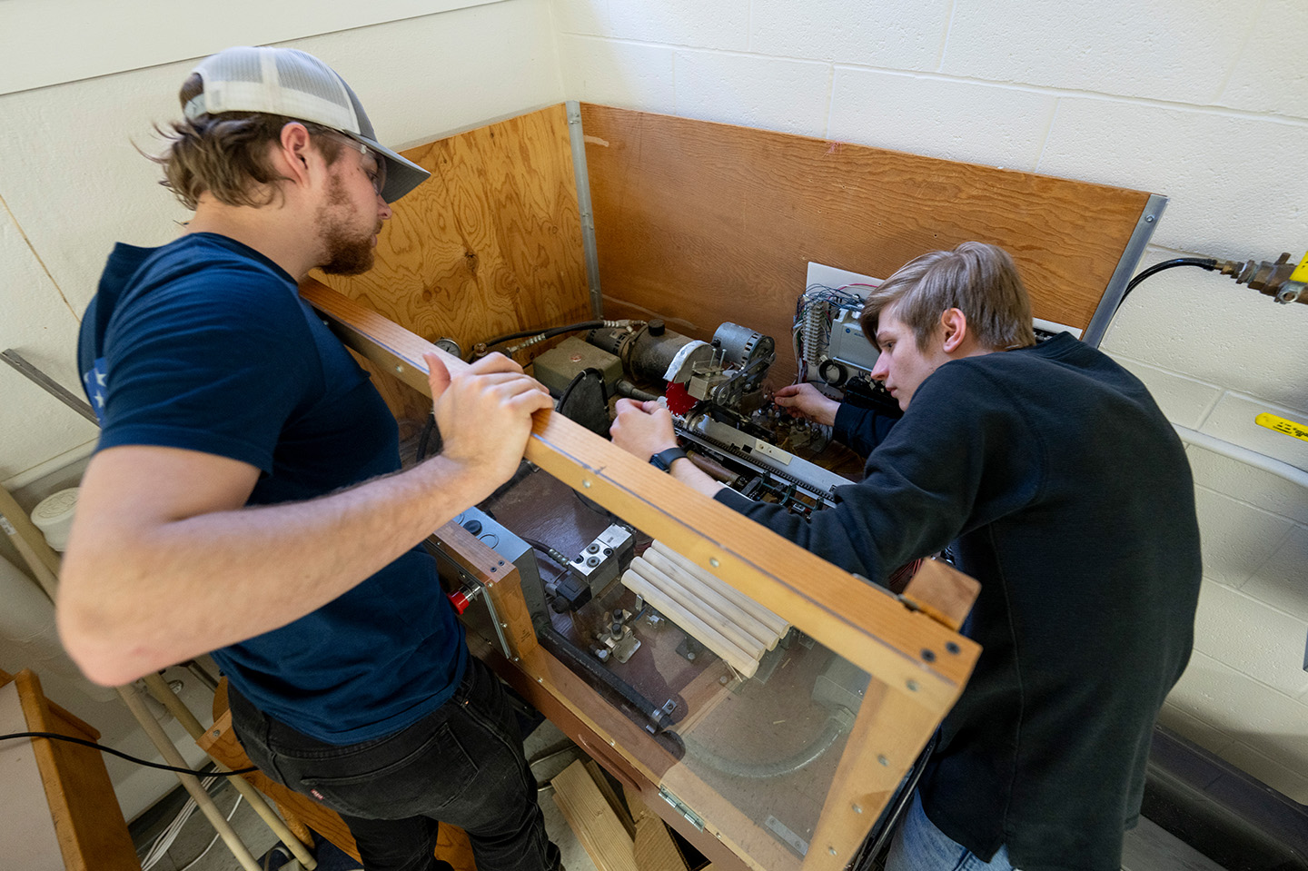 Electrical Engineering students working on a machine