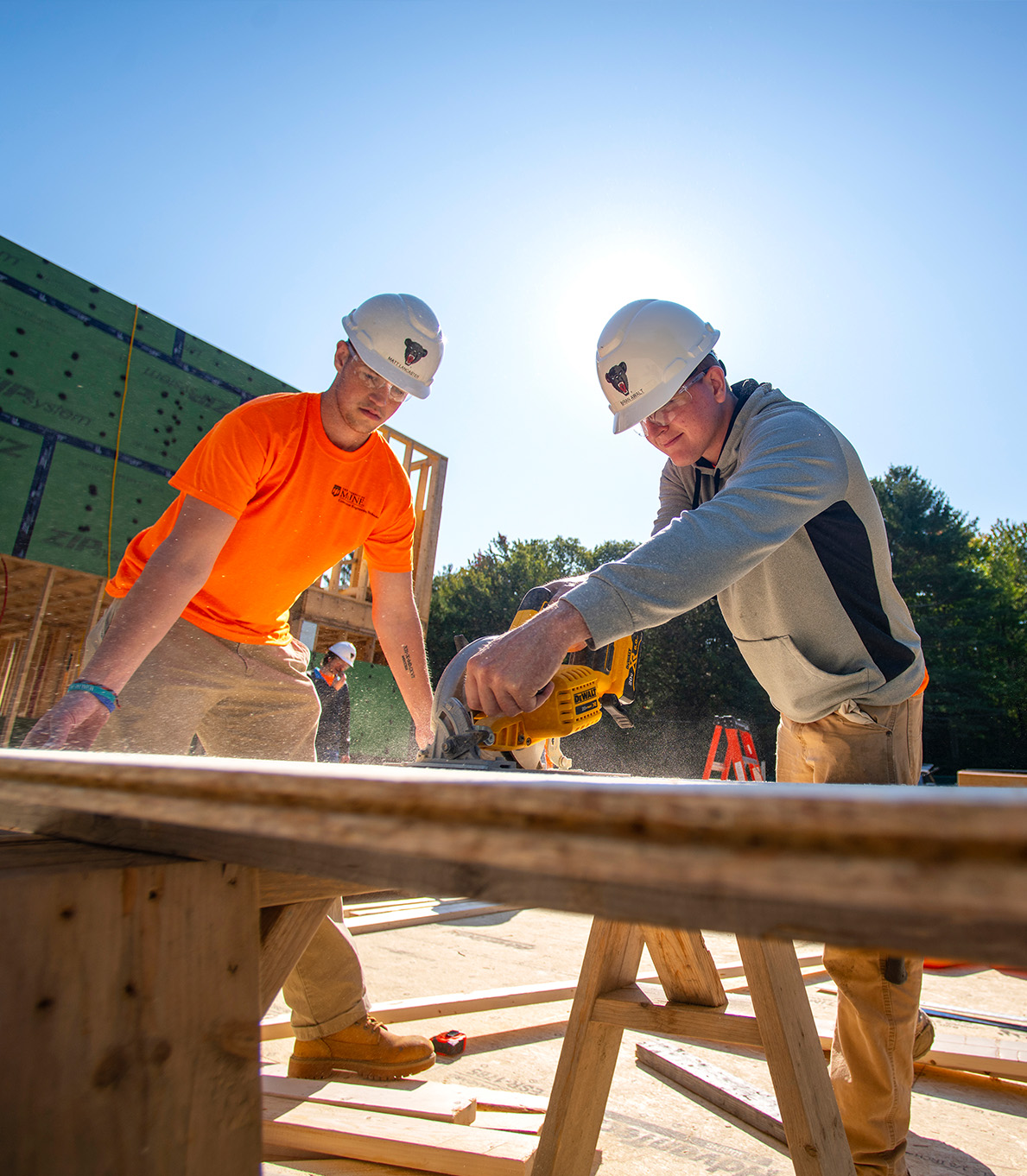 Engineering students wearing hard hats and working at a construction site