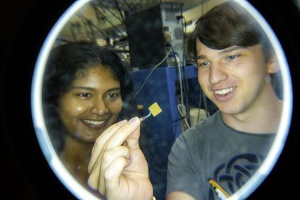 Students looking at a material and smiling