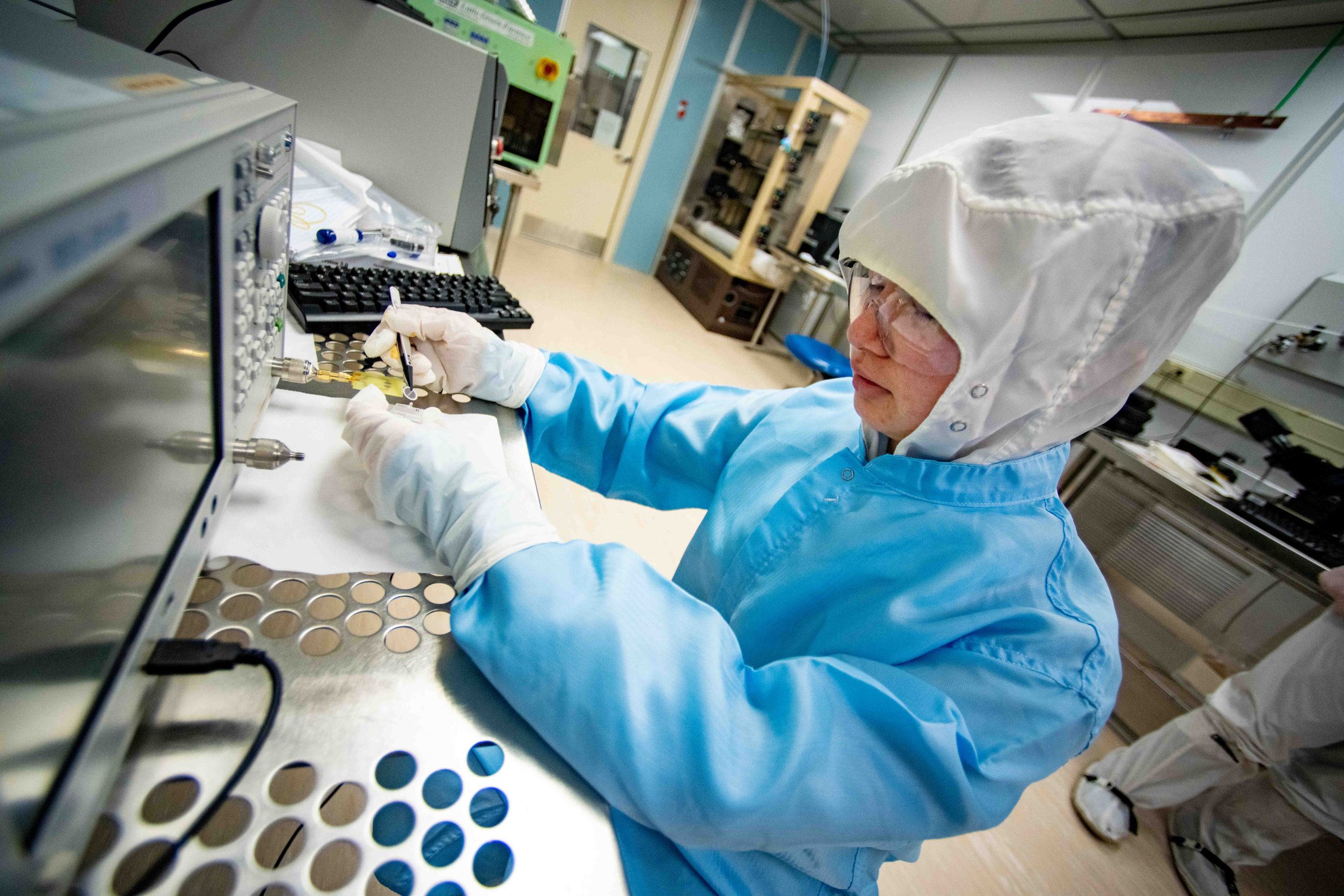 Student in a lab suit working in a lab