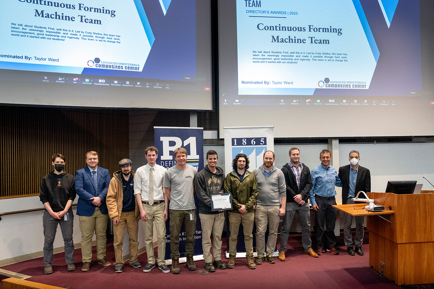 Engineers receiving awards standing at the front of a room
