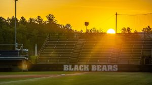 A photo of the sunset over a UMaine athletic field