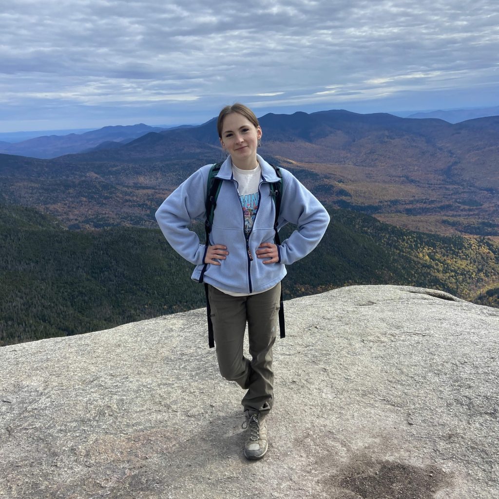 young woman standing on a mountain top
