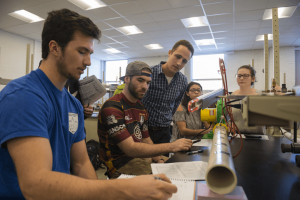 Five students working in a mechanical engineering lab