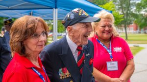 A veteran with smiles as he stands between two people during an event at UMaine