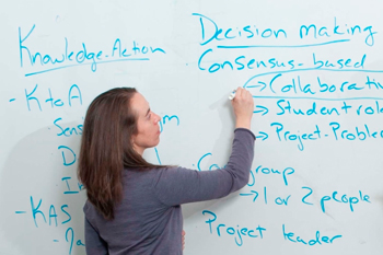 student writing on whiteboard