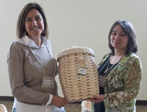 Maine Indian Basketmakers Alliance members Theresa Secord and Jennifer Neptune display an ash basket made by Richard Silliboy.