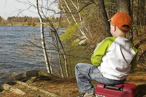 young boy fishing in lake