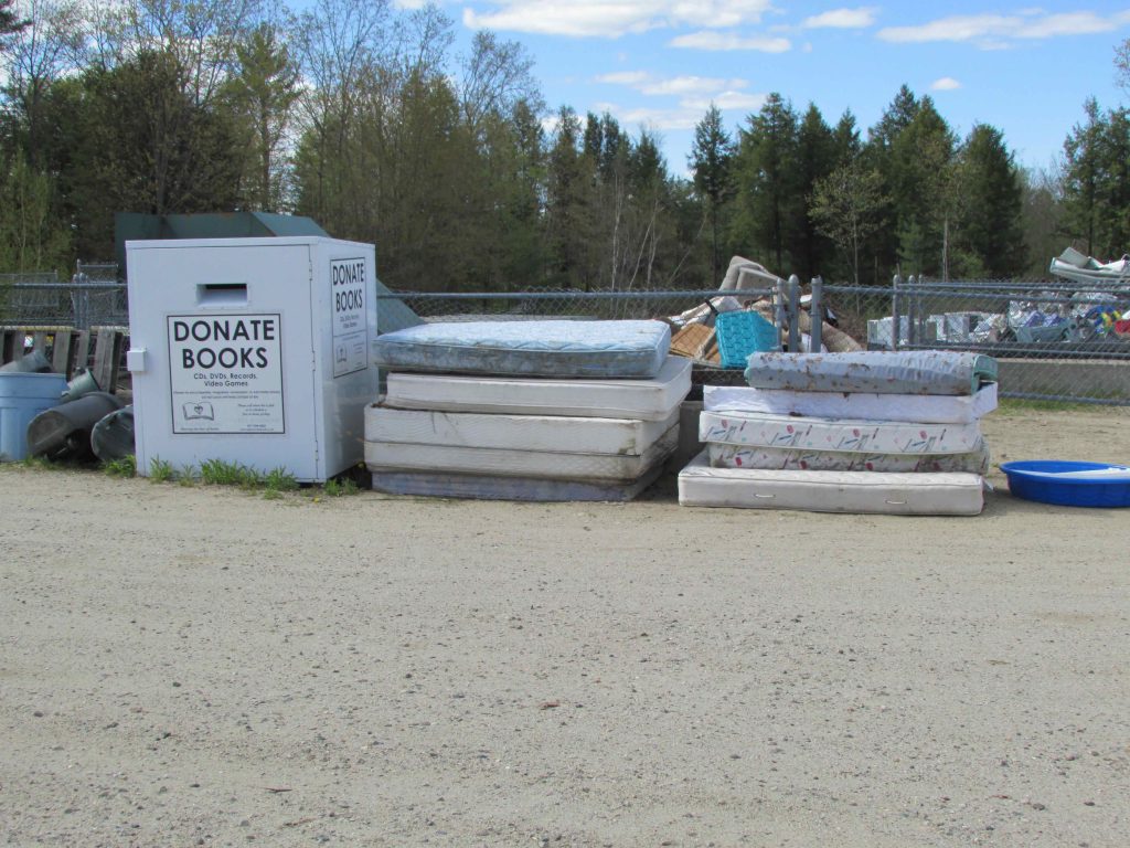 Image of book donation bin and discarded mattresses