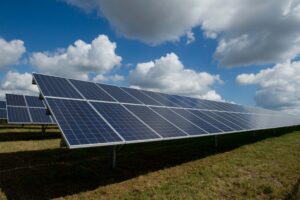 solar panels in field with sky and clouds