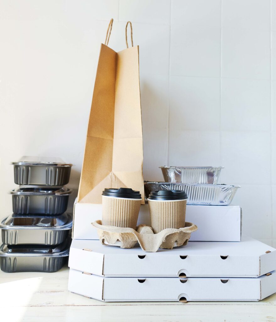 Variety of food takeout containers on counter in front of white background