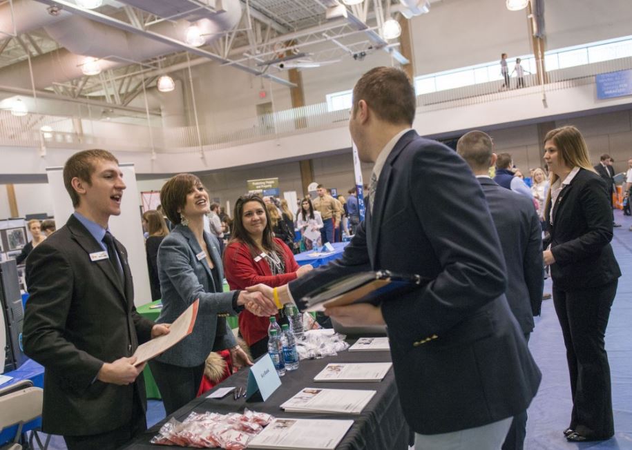 Employers greeting students at a University of Maine job fair