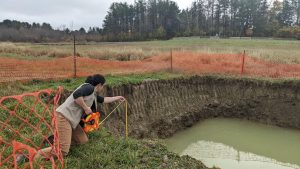 Rachel Schattman measures the depth of a shallow well