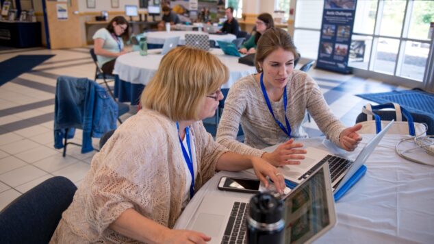 Two faculty members discussing over a topic on the computer