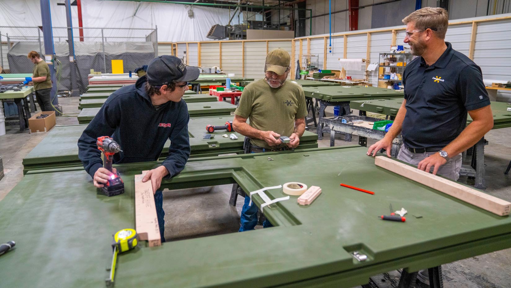 An image of three people standing next to a panel