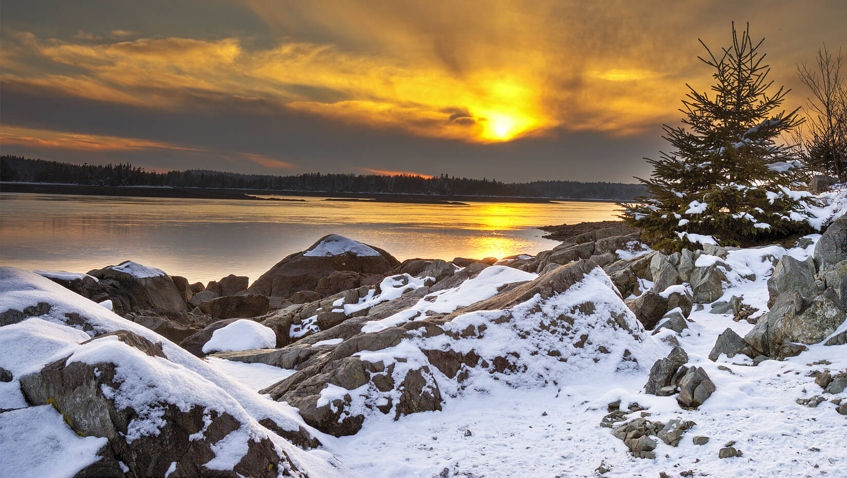 Sunset over a the snowy Maine coast.