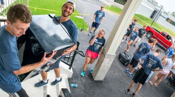 Volunteers help new students move into residence halls