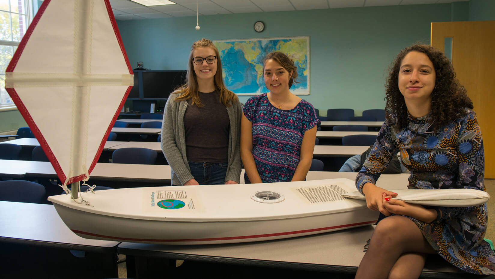 Members of the Marine Sciences Club post with a miniboat
