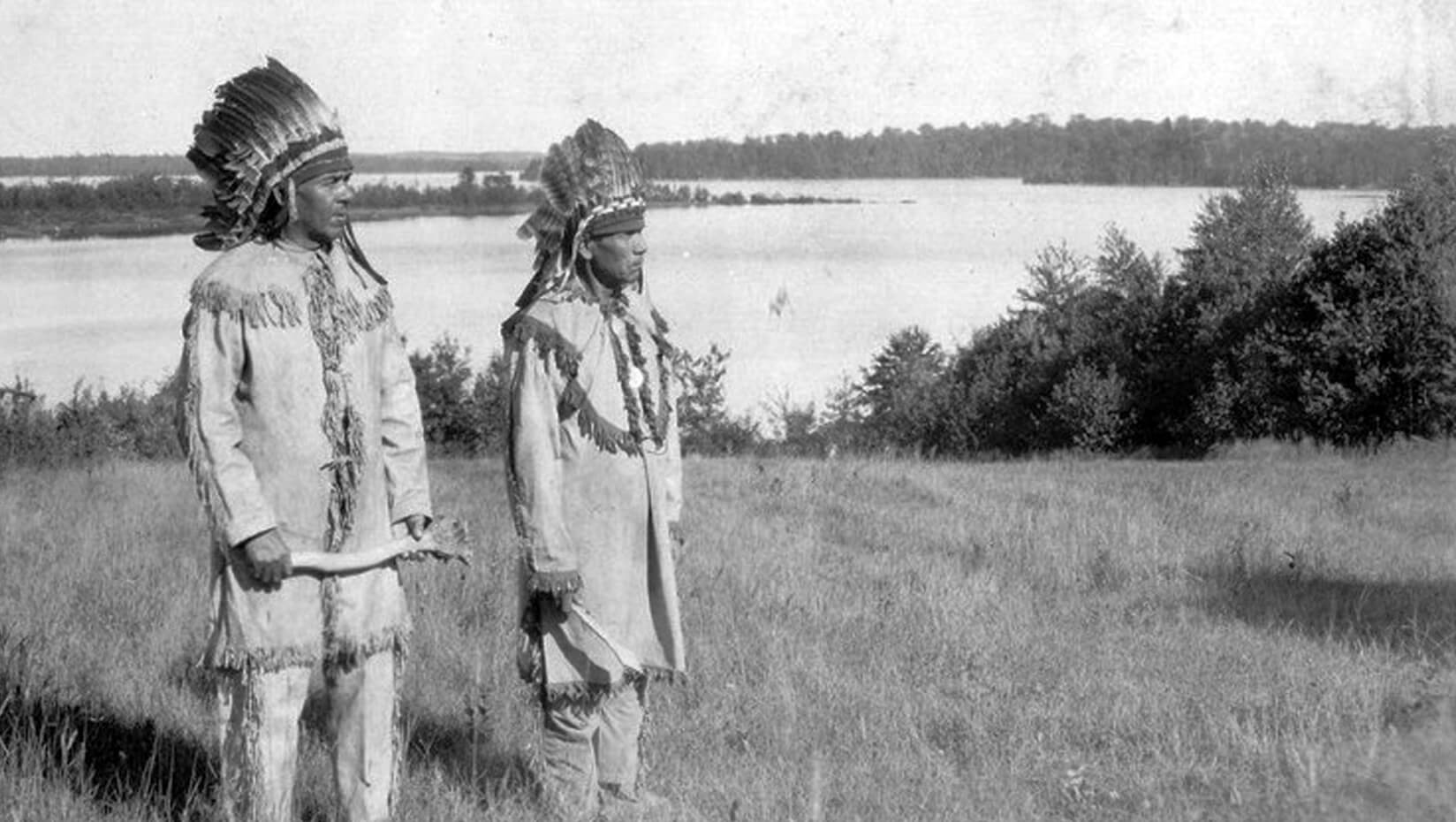 Two Native men standing in a field