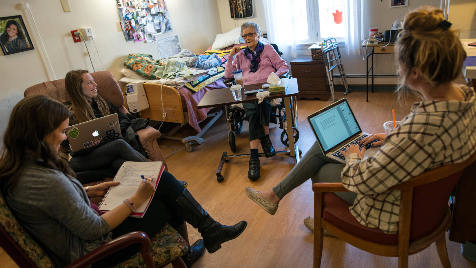 Students working with a resident at Orono Commons