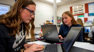 Middle school students using laptop computers