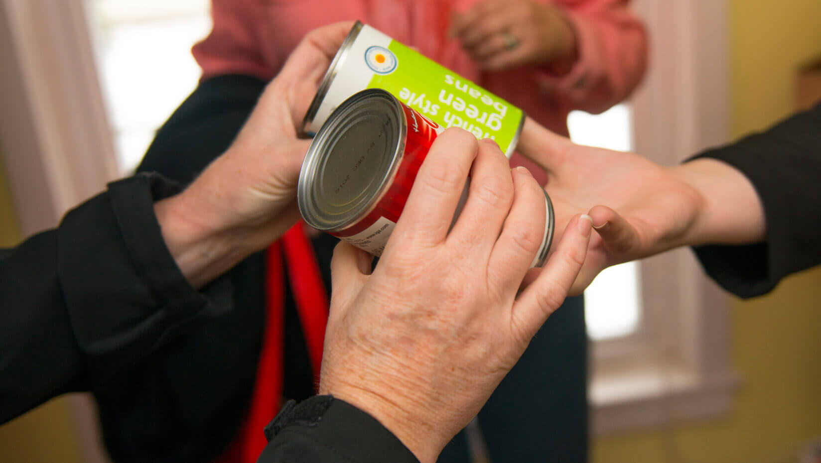 Hands accepting canned goods