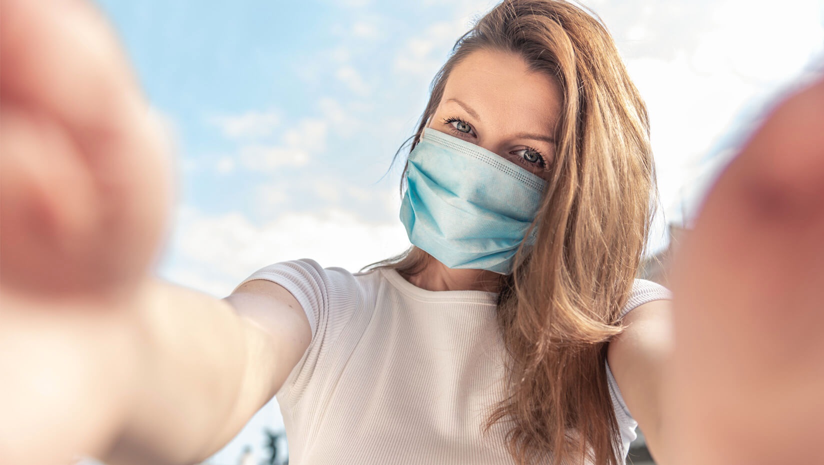 Woman taking a selfie while wearing a face mask