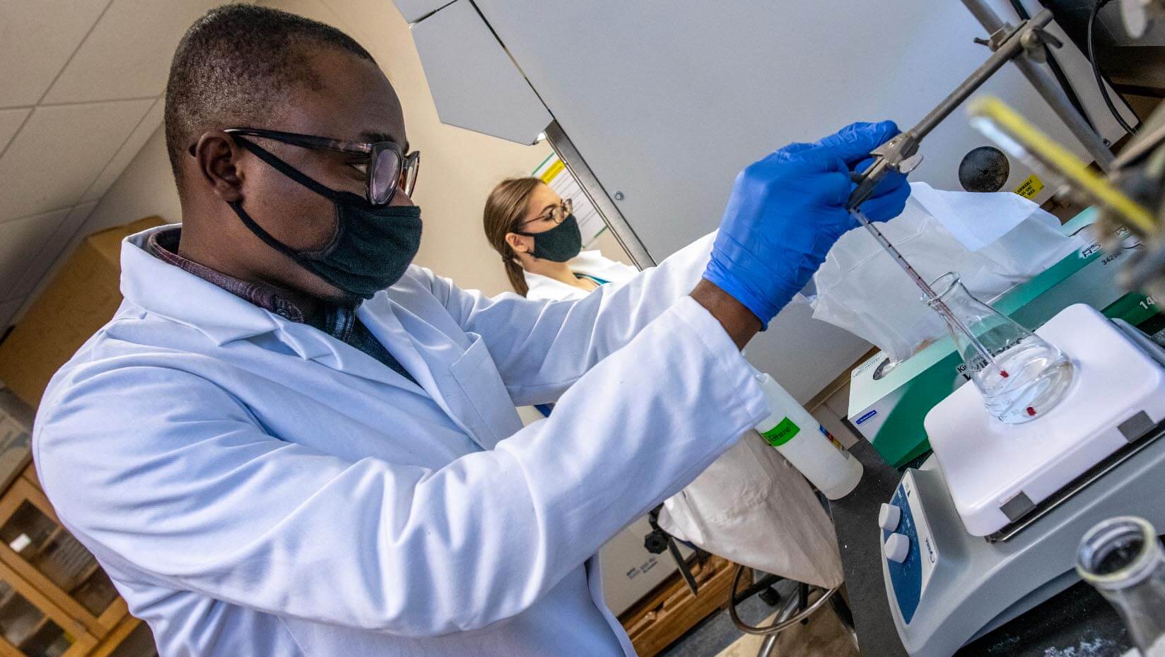 Students conducing lab research wearing lab coats