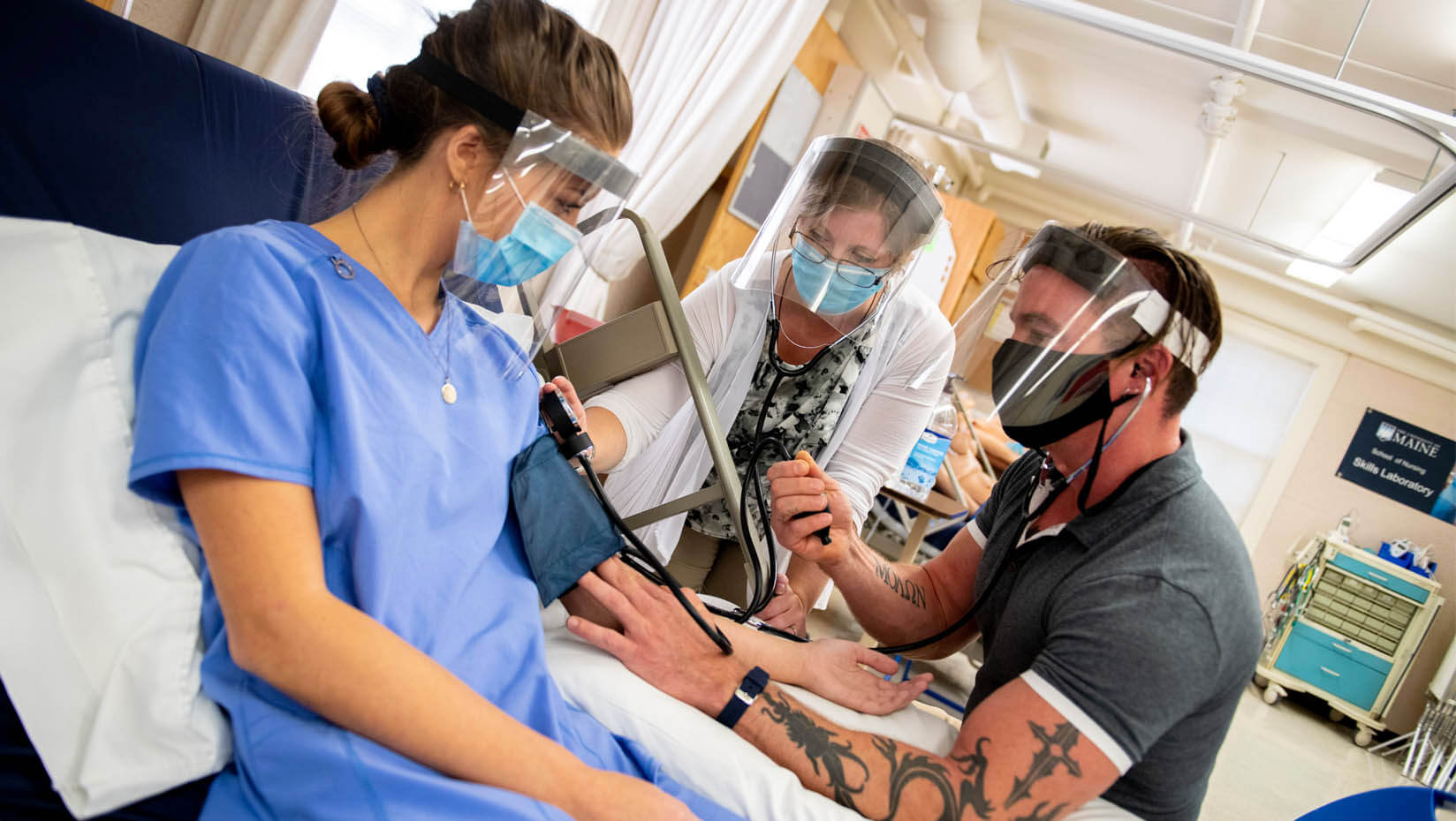 Students and an instructor work in a nursing lab class