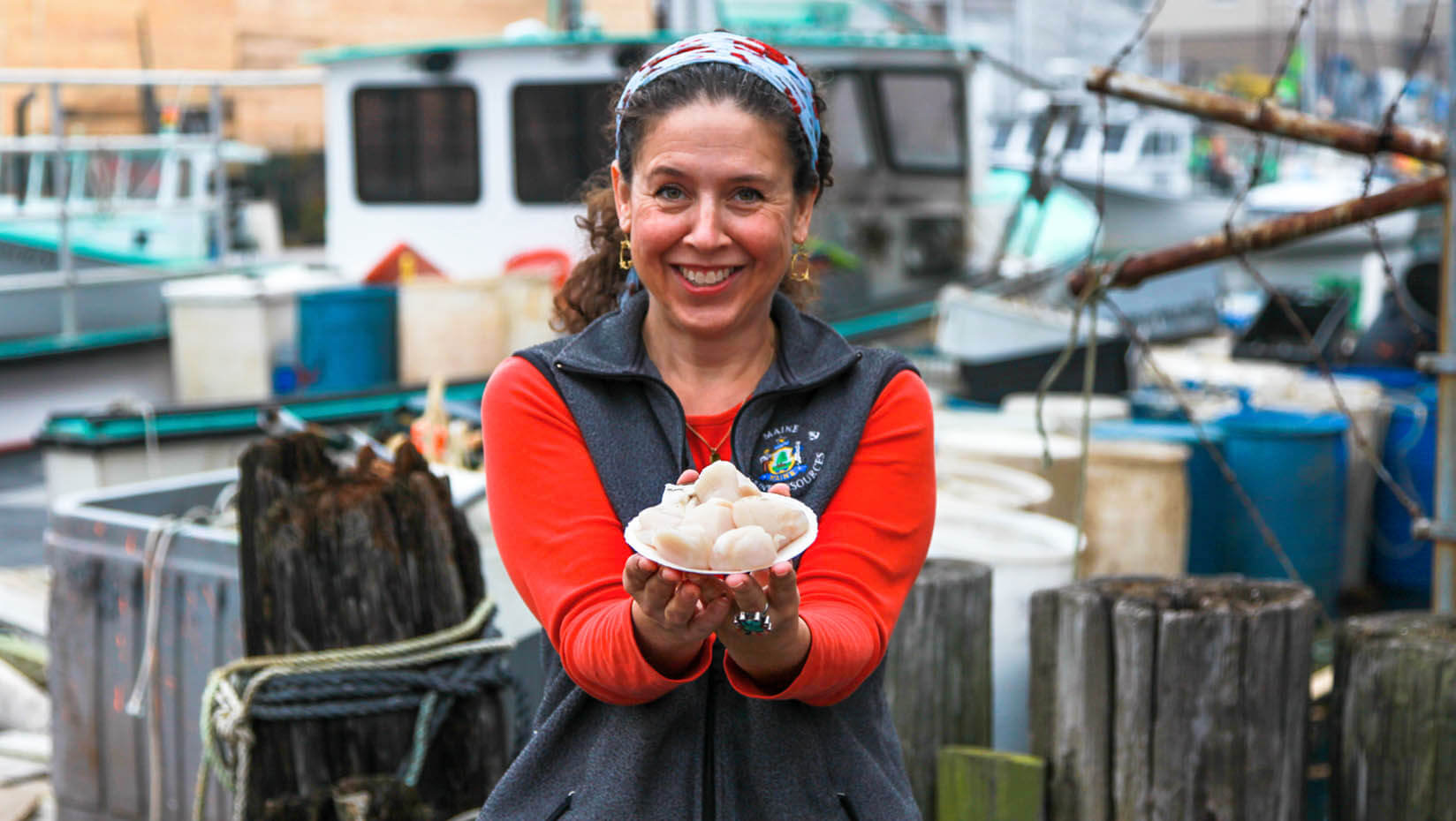 A woman holding a plate of scallops