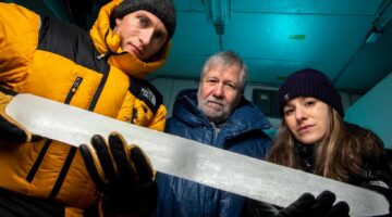 Three UMaine scientists hold an ice core