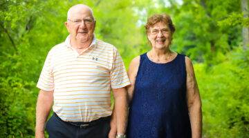 Photo of two older adults holding hands and facing the camera