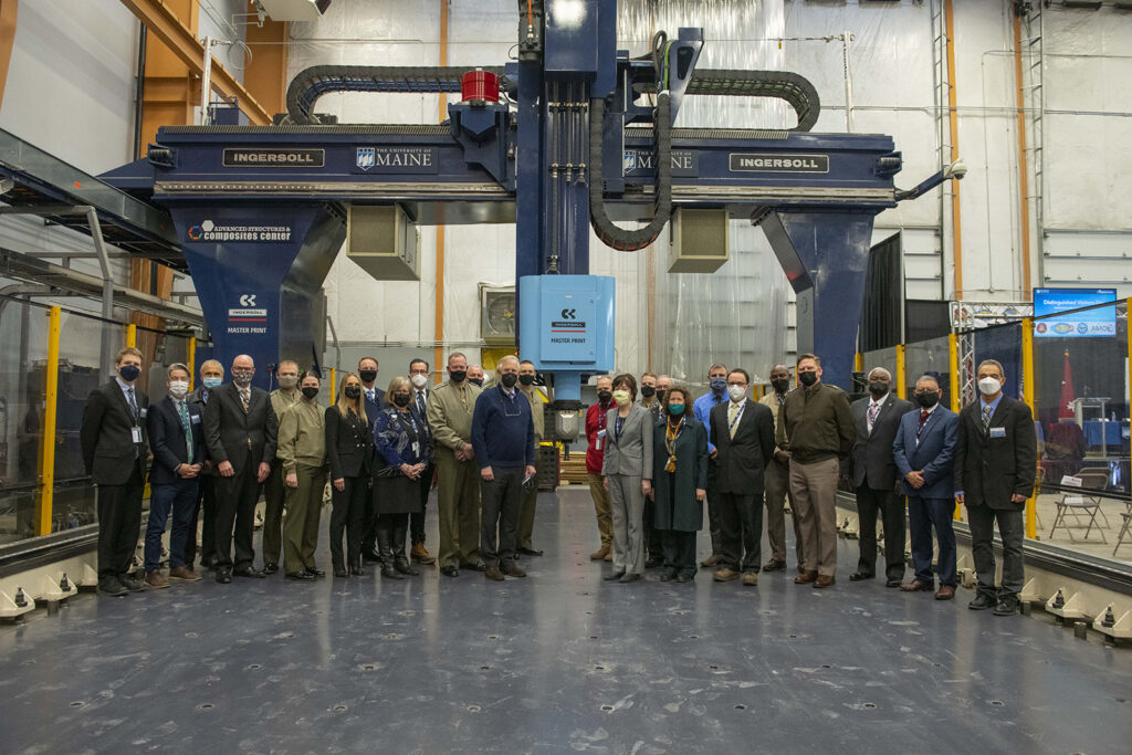 Photo of U.S. Senators Susan Collins and Angus King, U.S. Department of Defense leadership and University of Maine officials at the Feb. 25 event celebrating the UMaine Advanced Structures and Composites Center's production of the world’s largest 3D-printed logistics vessel for the U.S. Department of Defense.