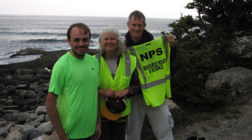 Photo of Kyle Capistrant-Fossa, Susan Brawley and Ladd Johnson standing by the shoreline in Acadia National Park.
