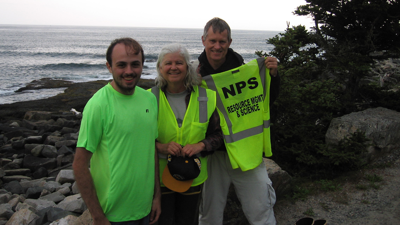 Photo of Kyle Capistrant-Fossa, Susan Brawley and Ladd Johnson standing by the shoreline in Acadia National Park.