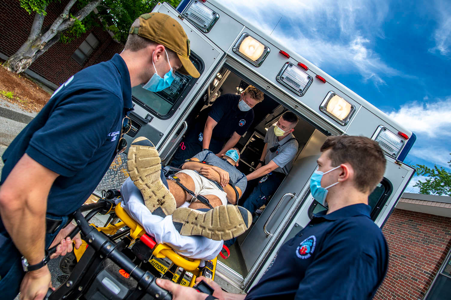 A patient is loaded into an ambulance during a simulation