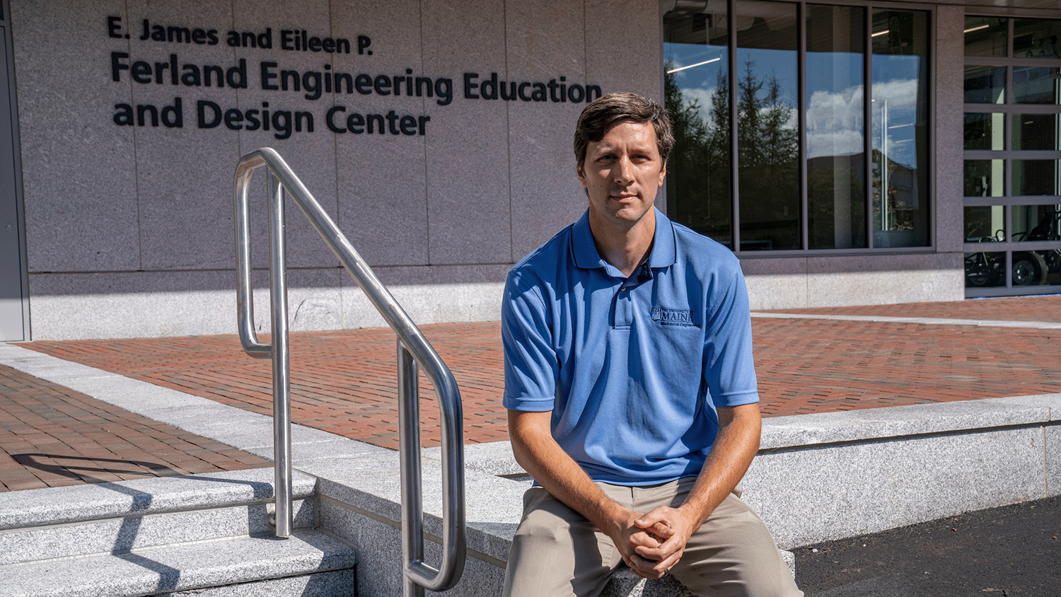 Justin Lapp sitting outside the Ferland Engineering Education and Design Center at the University of Maine