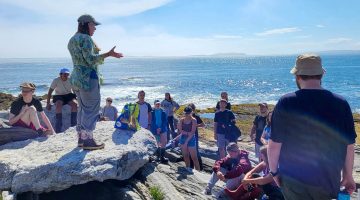 A photo of Heather Leslie speaking with first-year students on the Maine coast