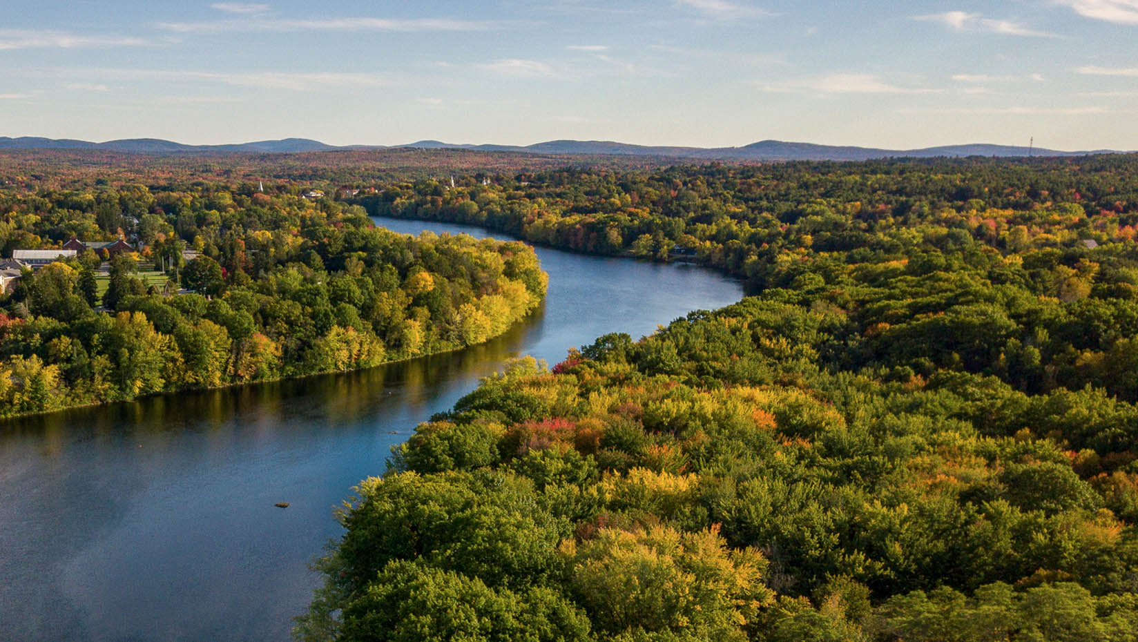 An aerial photo of Maine woods surrounding the Stillwater River in Orono