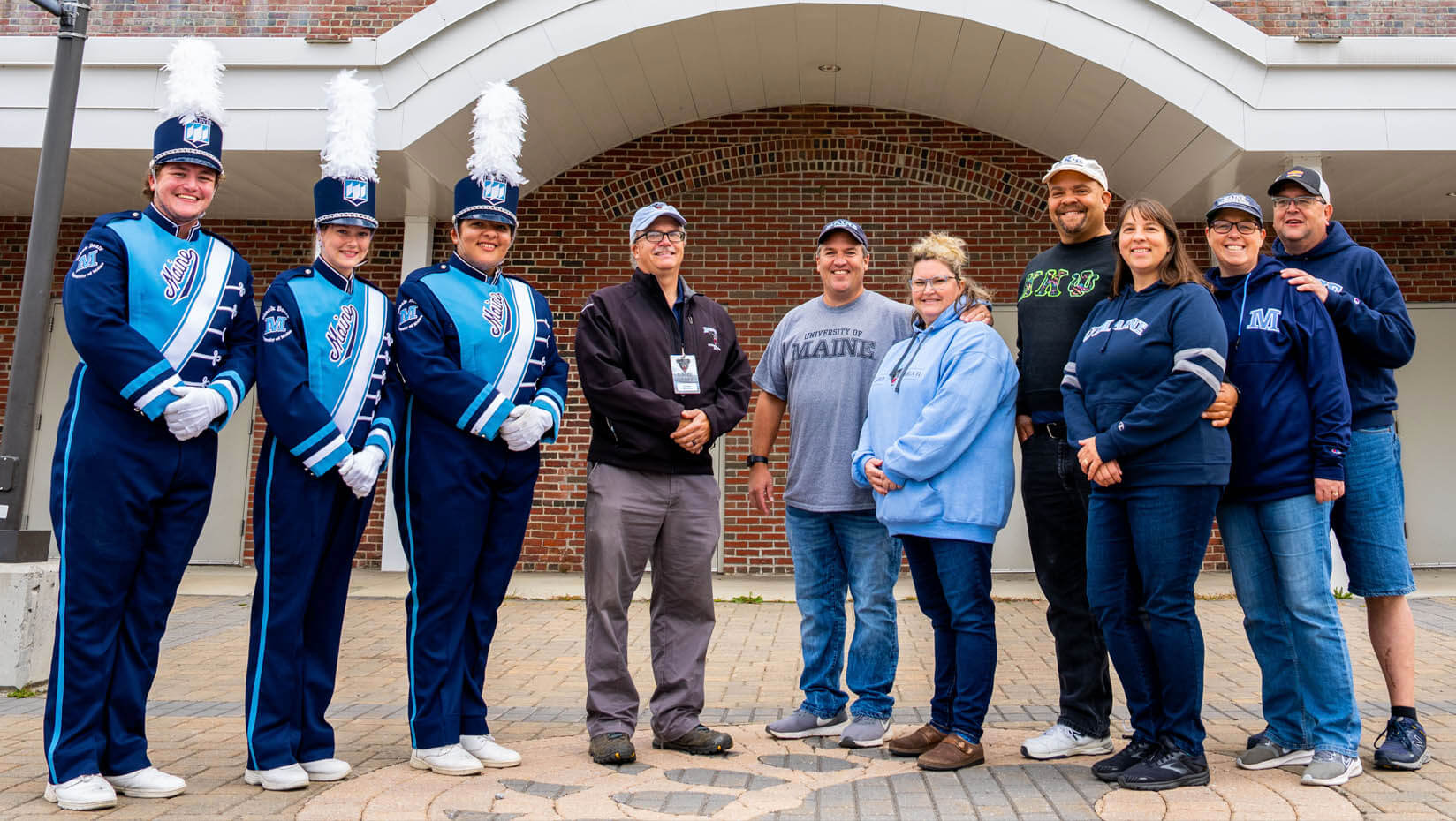 A photo of a group of people standing in front of UMaine's field house