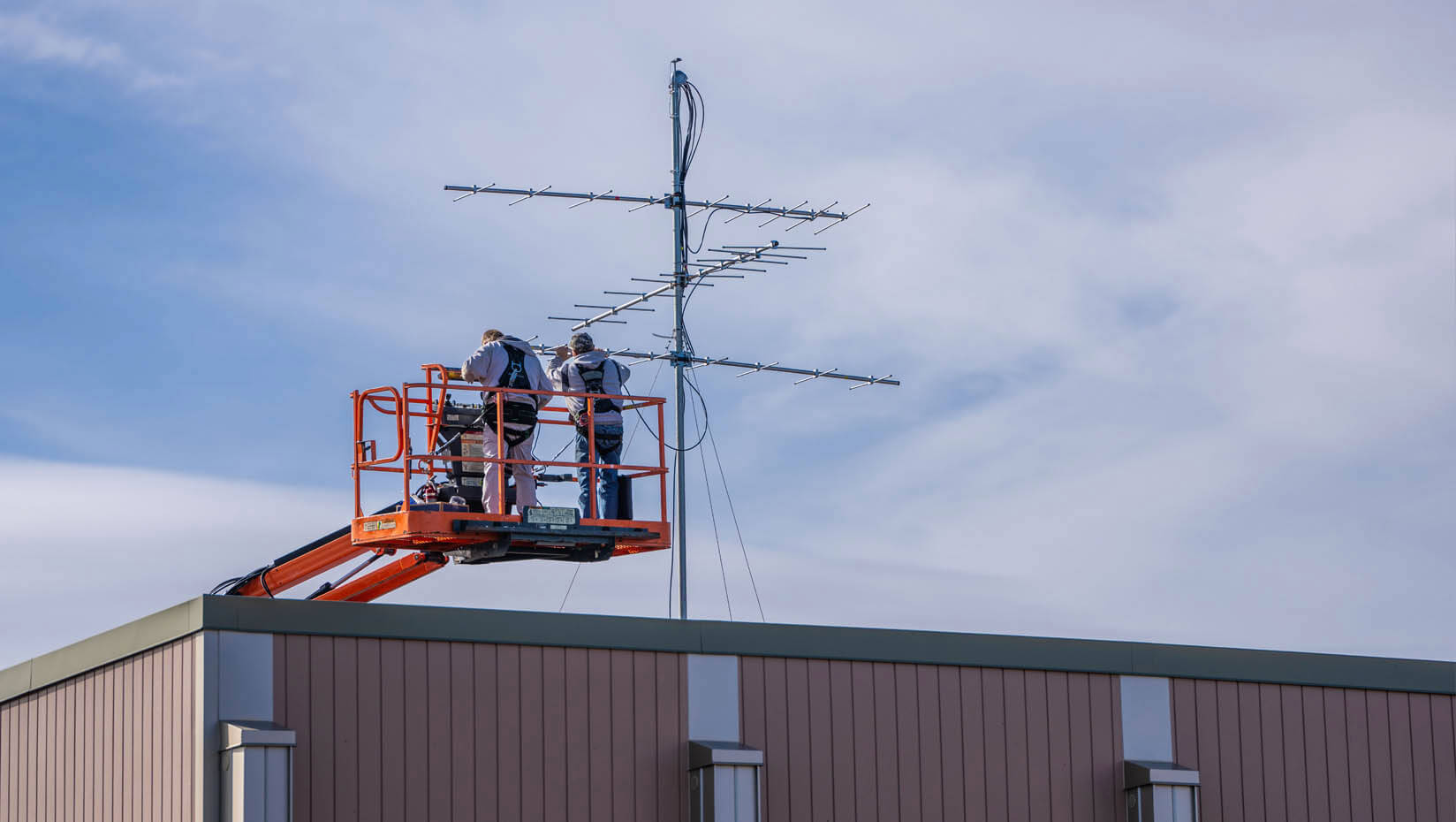 A photo of a wildlife tracker being installed on the roof of Nutting Hall