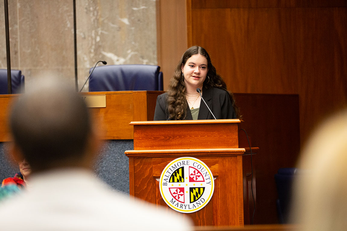 A photo of Miriam Talalay speaking at an awards ceremony