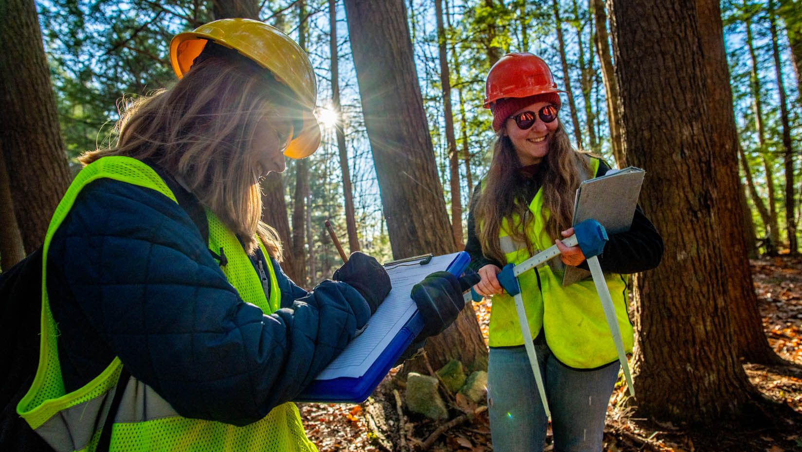 A photo of two women working in the Maine woods
