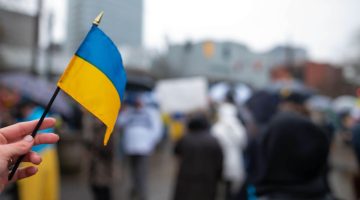A photo of someone holding the Ukrainian flag